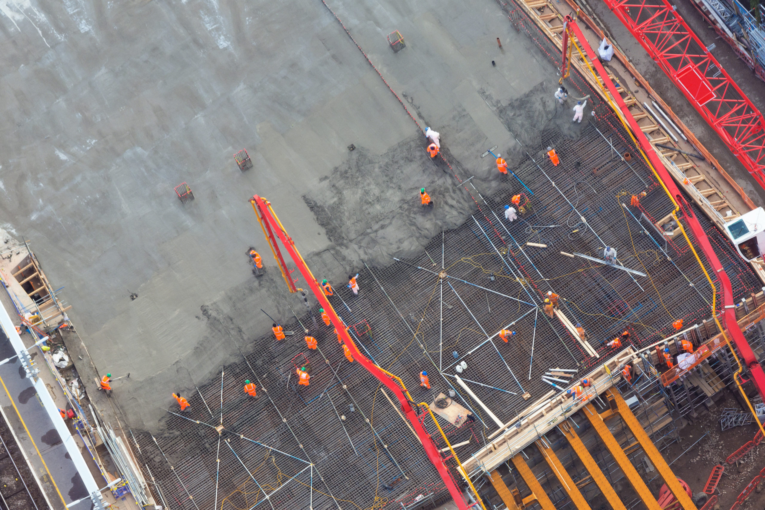 Workers are spreading concrete across a structure.